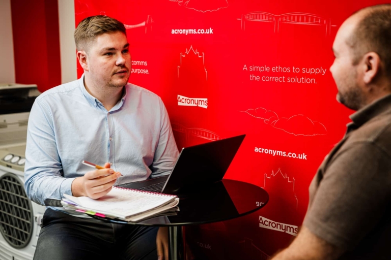 Two acronyms employees discussing work together