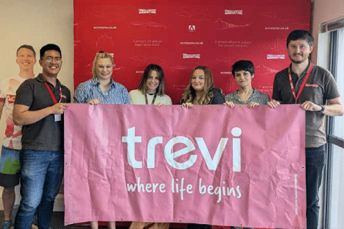 members of the team holding a Trevi banner